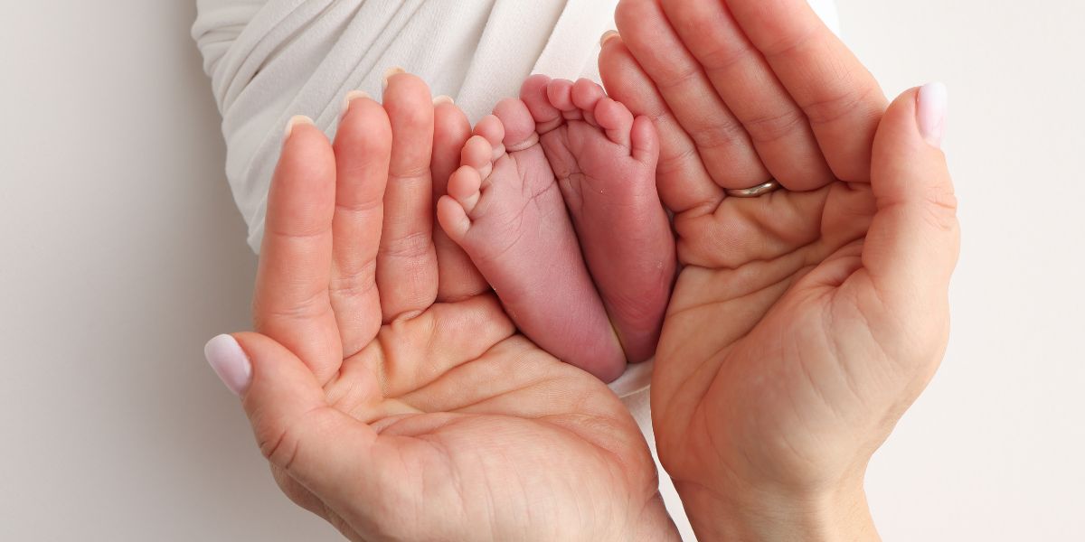 Newborn foot held by a woman's hands
