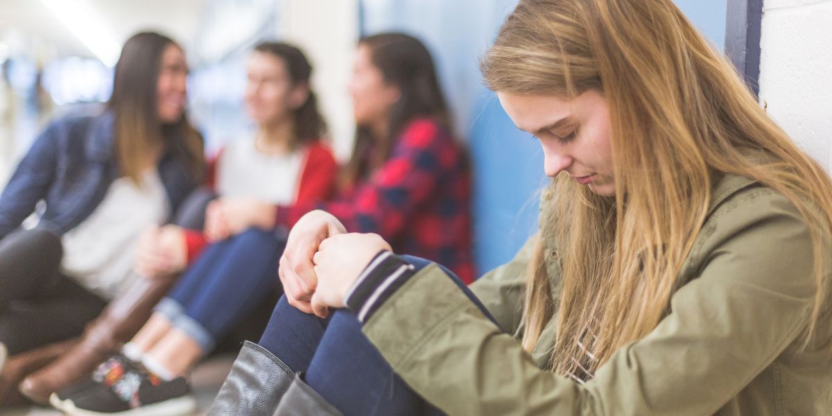 Teen alone in school hallway