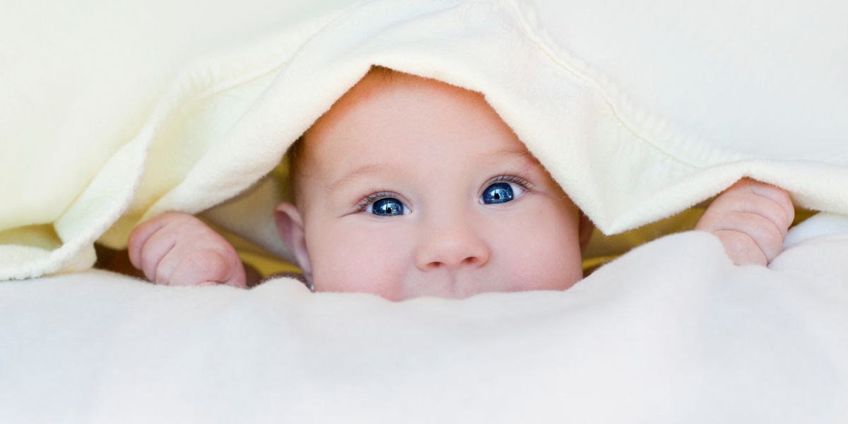 Baby showing head under blanket