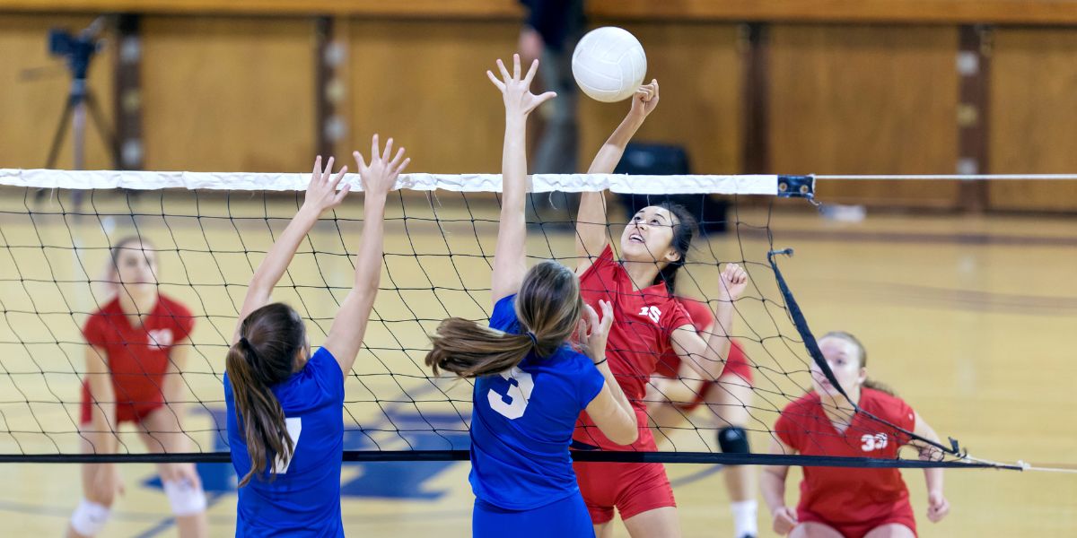 Teen girls playing volleyball