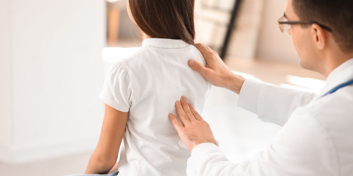 Clinician examining patient's back