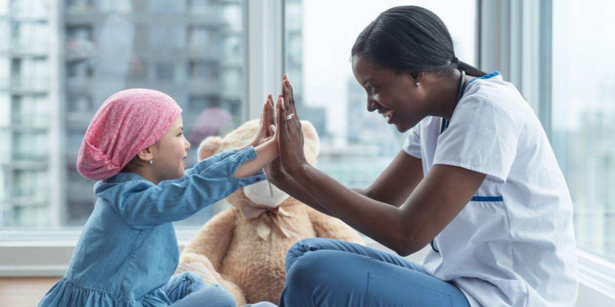 Childhood cancer patient gives double high five to her oncologist