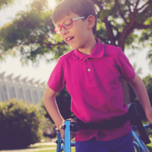 Child with glasses standing outside